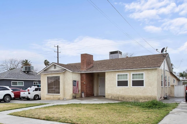 view of front facade with central AC unit and a front yard