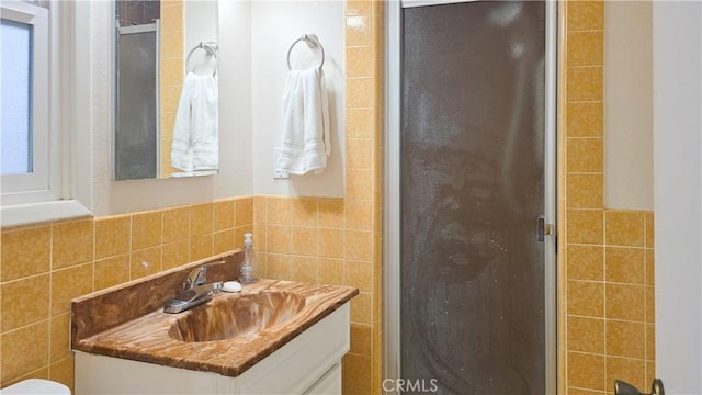 bathroom with vanity and tile walls