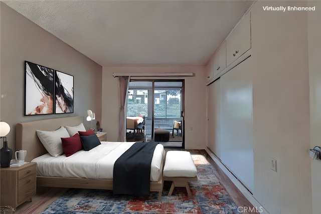 bedroom with wood-type flooring and access to exterior