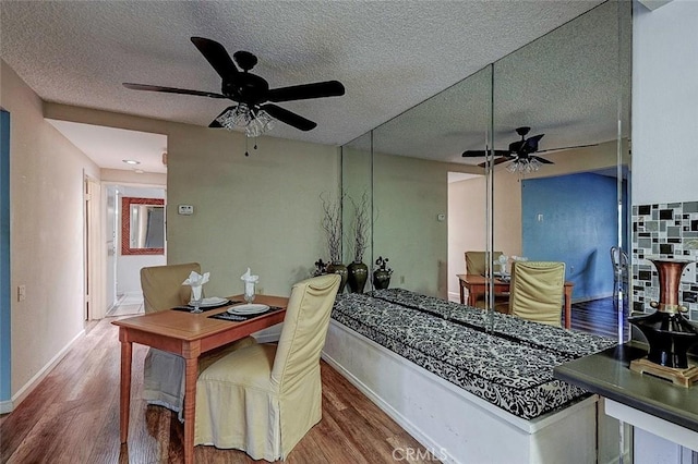 dining area featuring wood-type flooring, a textured ceiling, and ceiling fan