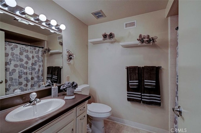 bathroom featuring vanity, tile patterned flooring, and toilet