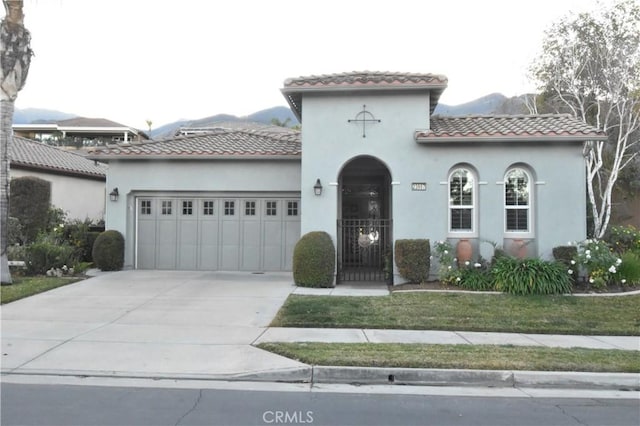 mediterranean / spanish-style house featuring a garage and a mountain view