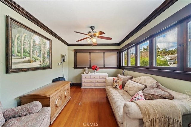 living room with ceiling fan, ornamental molding, and wood-type flooring