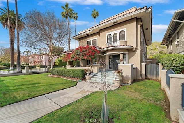 mediterranean / spanish house with a balcony and a front yard