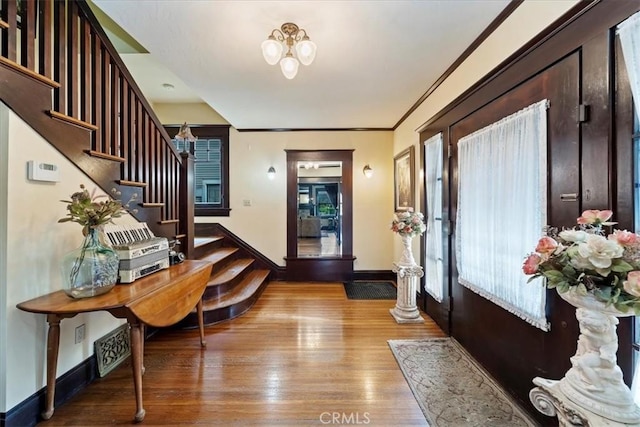 entryway with crown molding, plenty of natural light, and light hardwood / wood-style floors