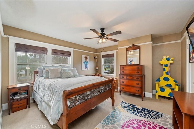 carpeted bedroom with ceiling fan and multiple windows