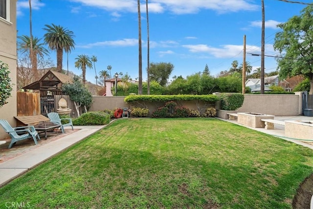 view of yard featuring a fire pit and a patio