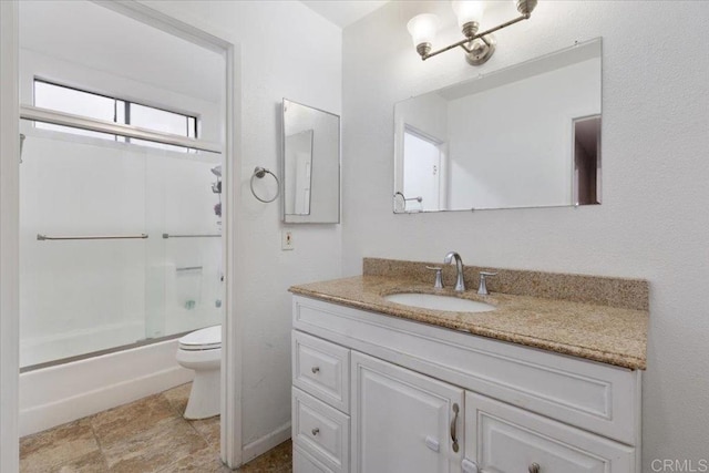 full bathroom with enclosed tub / shower combo, vanity, and toilet