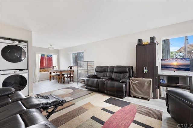 living room featuring stacked washer and clothes dryer and plenty of natural light