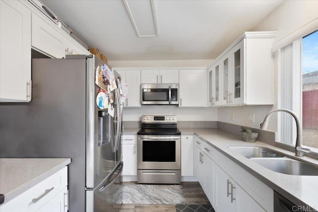 kitchen with stainless steel appliances, sink, and white cabinets