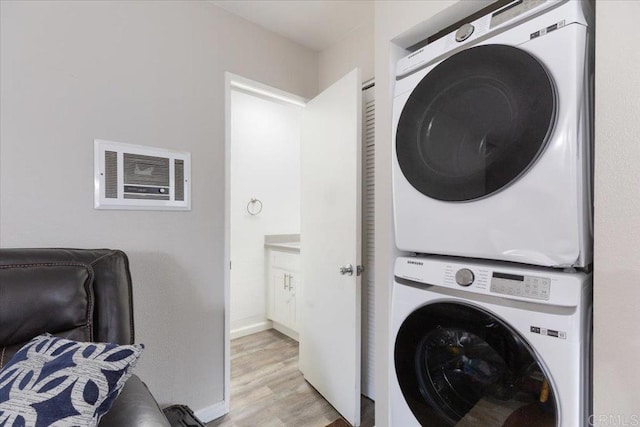 washroom featuring stacked washer and clothes dryer and light hardwood / wood-style floors