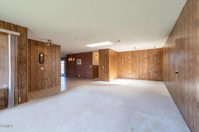 unfurnished room featuring wooden walls and a textured ceiling