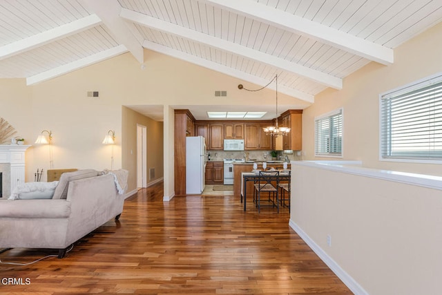 living room with dark hardwood / wood-style flooring, a notable chandelier, beam ceiling, and high vaulted ceiling