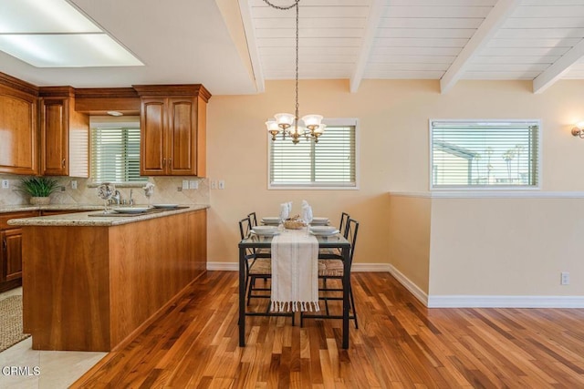 dining room featuring dark hardwood / wood-style flooring, beamed ceiling, and an inviting chandelier