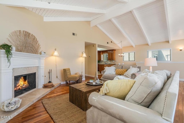 living room with hardwood / wood-style flooring, high vaulted ceiling, a high end fireplace, and beam ceiling