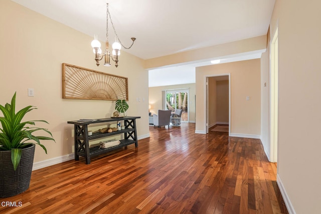 hallway featuring dark hardwood / wood-style flooring and a chandelier