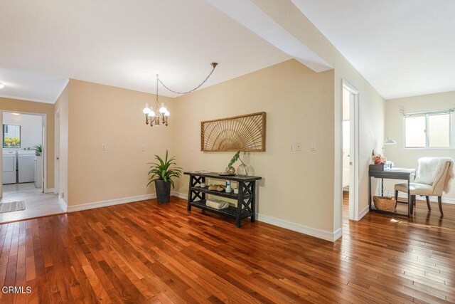 3233 Playa Ct, Oxnard, CA 93035 - spare room featuring washing machine and dryer, hardwood / wood-style floors, healthy amount of natural light, and a chandelier