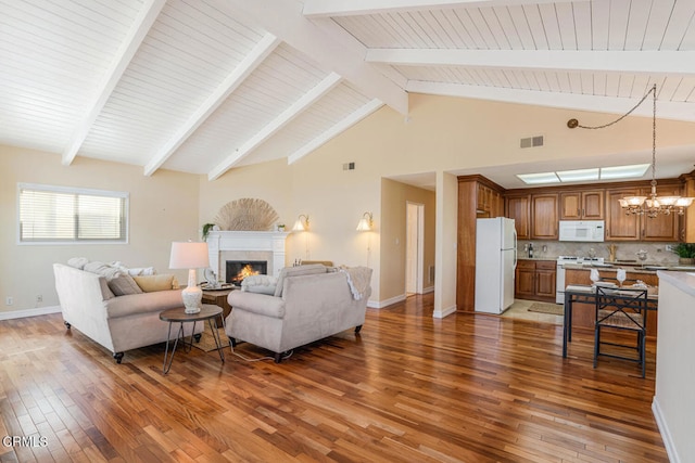 3233 Playa Ct, Oxnard, CA 93035 - living area with wood-type flooring, a warm lit fireplace, a chandelier, high vaulted ceiling, and a wood ceiling with exposed beams
