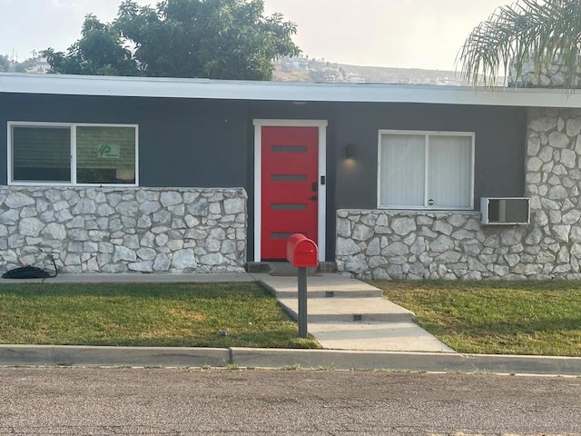 entrance to property featuring a lawn