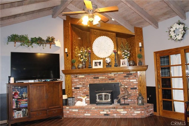 living room with lofted ceiling with beams, a wood stove, wood ceiling, ceiling fan, and dark wood-type flooring