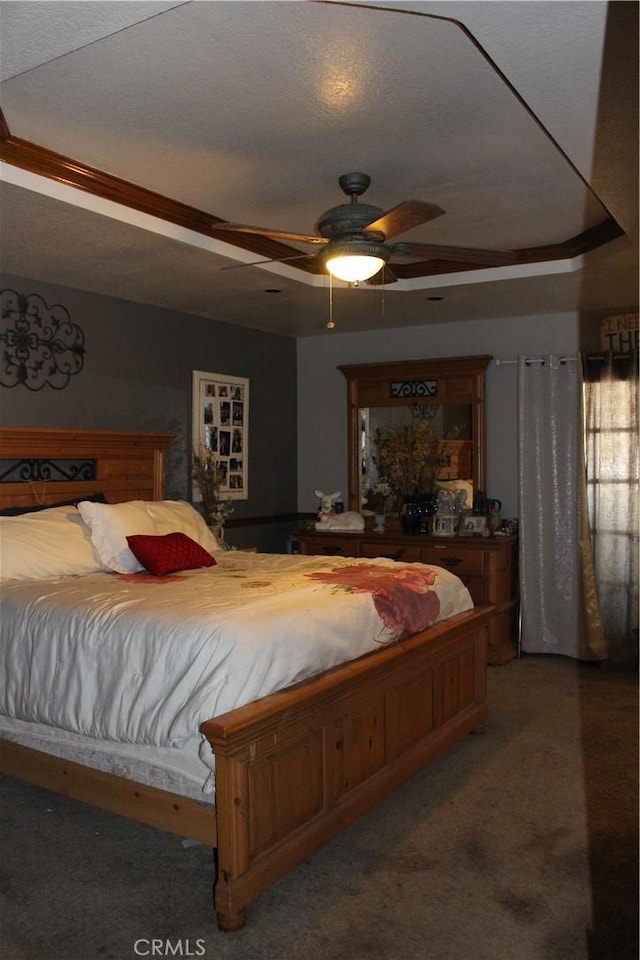 bedroom featuring a textured ceiling, a raised ceiling, and ceiling fan