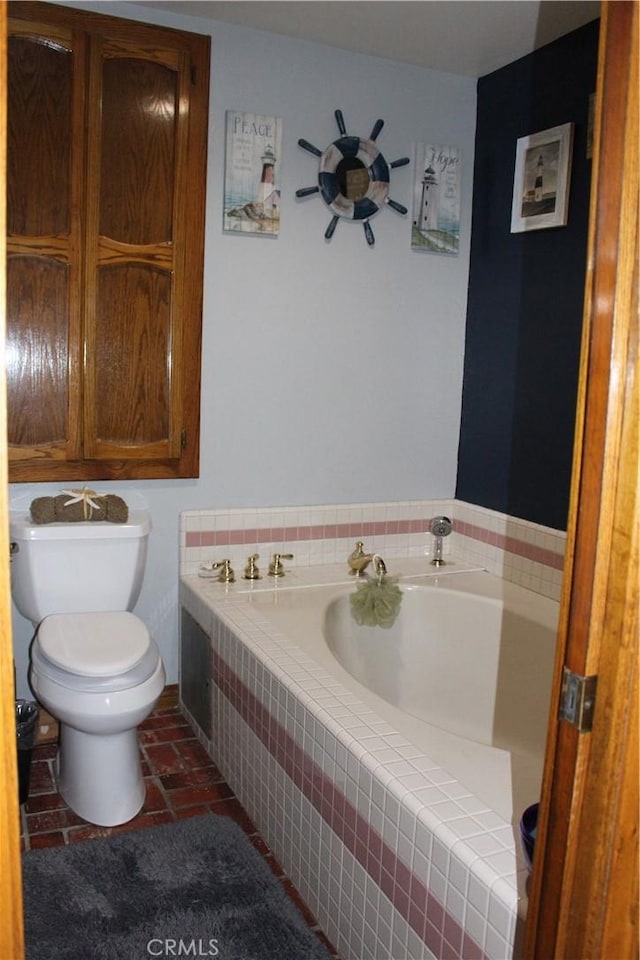 bathroom with tile patterned floors, toilet, and tiled tub