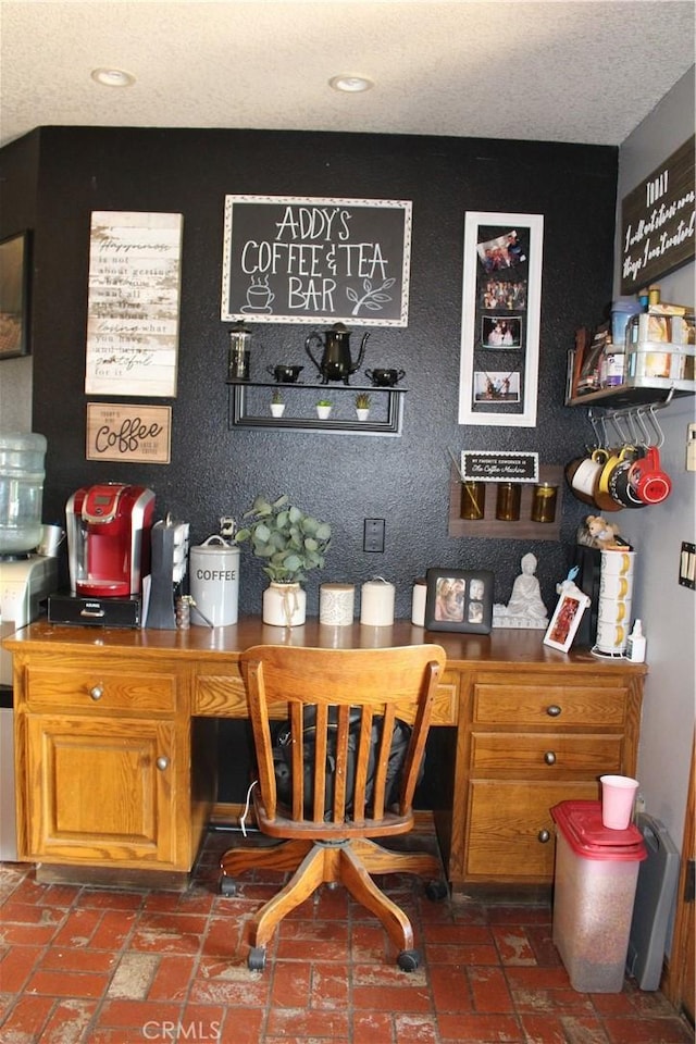 bar with built in desk and a textured ceiling