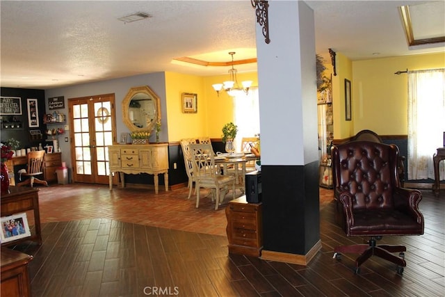 interior space with a wealth of natural light, dark wood-type flooring, french doors, and a chandelier