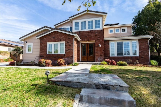 view of front facade featuring french doors, brick siding, a front lawn, and solar panels