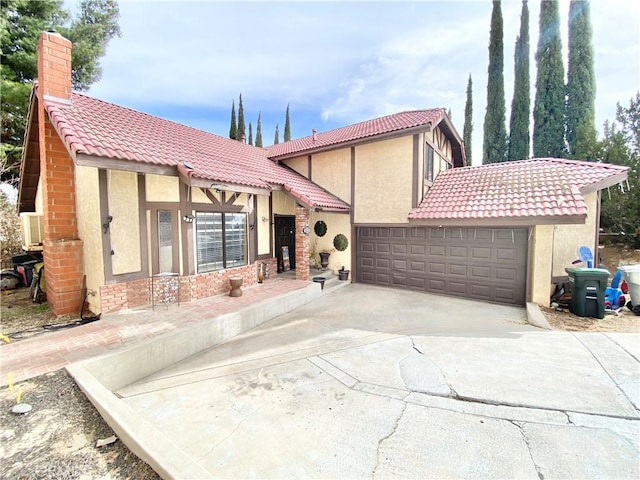 view of front of property with a garage, stucco siding, and a tiled roof