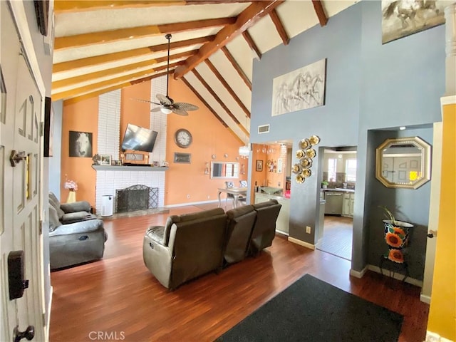 living room with hardwood / wood-style floors, a fireplace, beamed ceiling, and ceiling fan