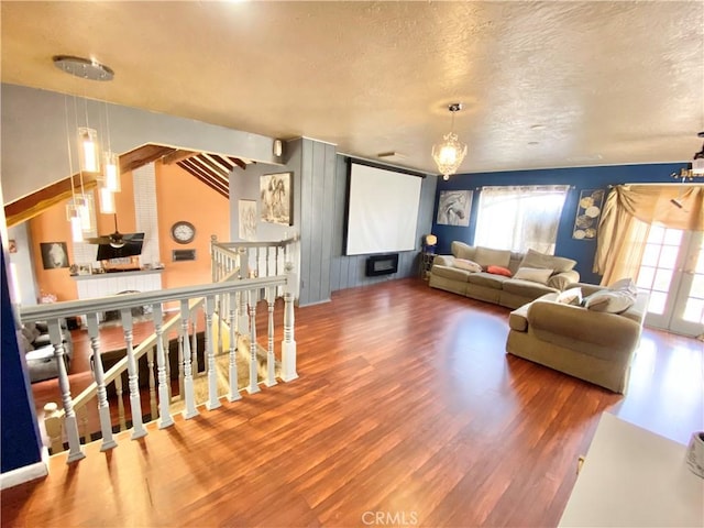 living room featuring hardwood / wood-style flooring, a textured ceiling, and a notable chandelier