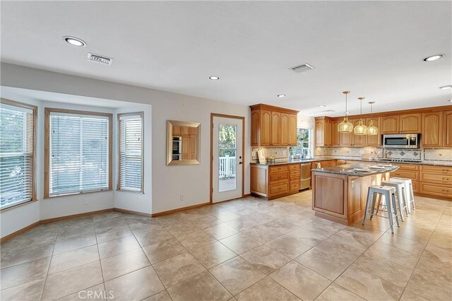 31750 1st St, Acton, CA 93510 - kitchen featuring backsplash, appliances with stainless steel finishes, visible vents, and a kitchen island