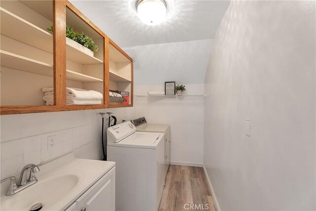 31750 1st St, Acton, CA 93510 - laundry room with baseboards, washing machine and clothes dryer, a sink, and light wood-style floors