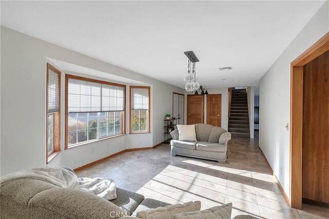 31750 1st St, Acton, CA 93510 - living room with stairway, visible vents, light tile patterned floors, baseboards, and a chandelier