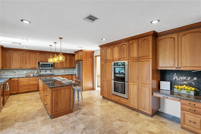 31750 1st St, Acton, CA 93510 - kitchen featuring dark stone counters, a kitchen breakfast bar, decorative backsplash, appliances with stainless steel finishes, and visible vents