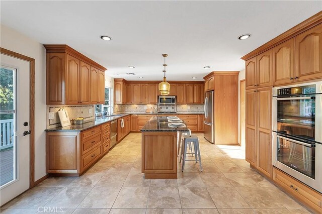 31750 1st St, Acton, CA 93510 - kitchen featuring stainless steel appliances, a center island, a sink, dark stone counters, and recessed lighting