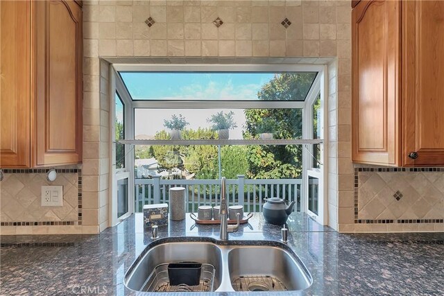 31750 1st St, Acton, CA 93510 - interior space with brown cabinetry, dark stone counters, decorative backsplash, and a sink