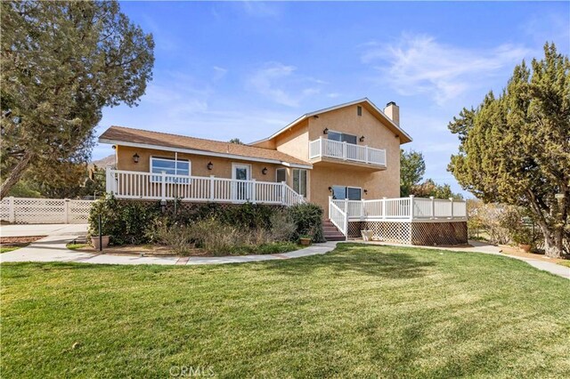 31750 1st St, Acton, CA 93510 - view of front of home with a balcony, a chimney, a front lawn, stucco siding, and a wooden deck