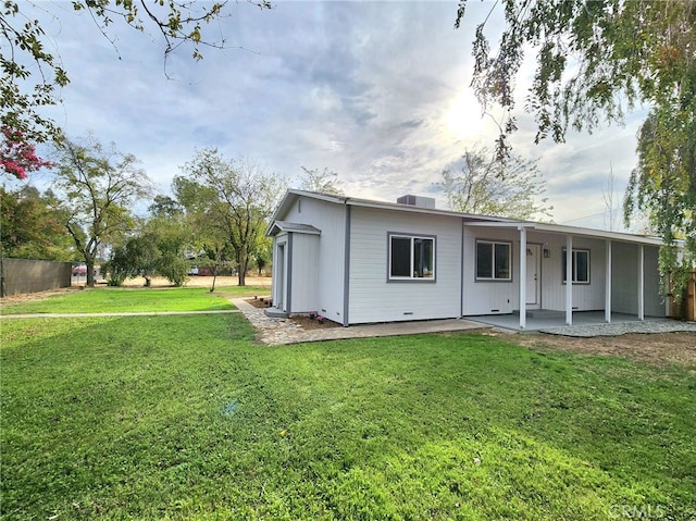 rear view of house featuring a yard and a patio area