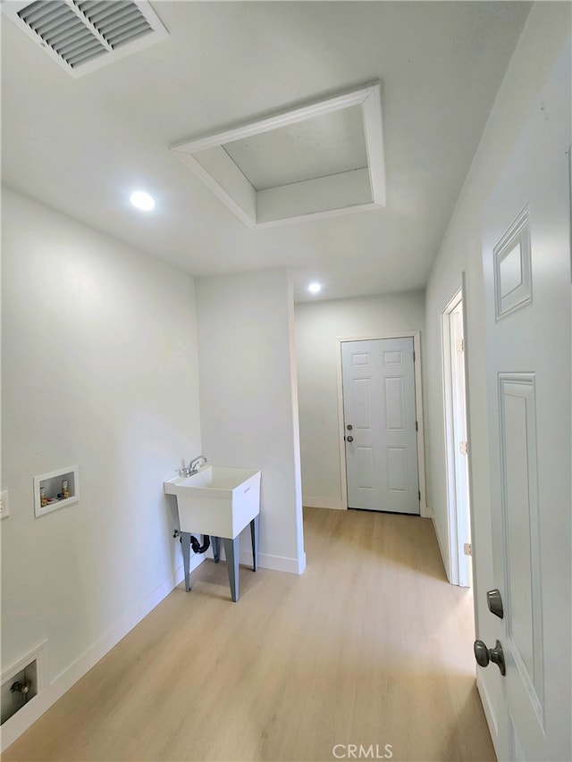 laundry room featuring hookup for a washing machine, sink, and light wood-type flooring