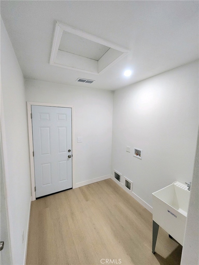 washroom with washer hookup and light hardwood / wood-style flooring