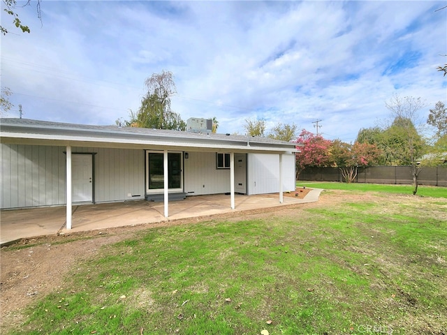 back of property with a yard and a patio