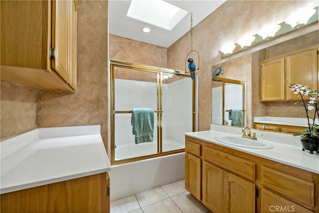 bathroom with vanity, shower / bath combination with glass door, a skylight, and tile patterned flooring