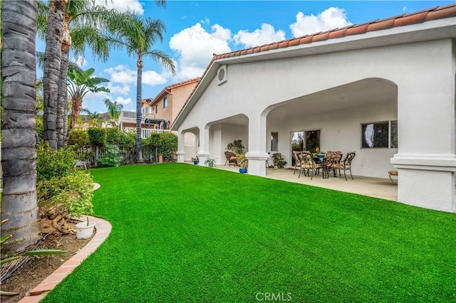 back of house featuring a lawn and a patio area