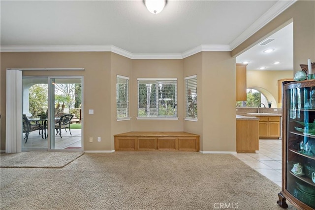 living room with ornamental molding, sink, and light carpet