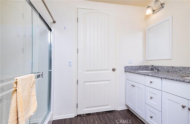 bathroom featuring vanity, hardwood / wood-style floors, and a shower with shower door