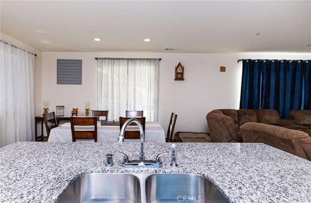 kitchen featuring sink and light stone counters