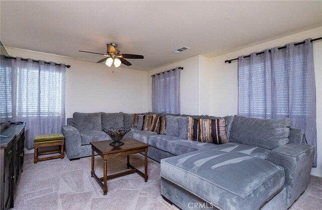 carpeted living room with ceiling fan