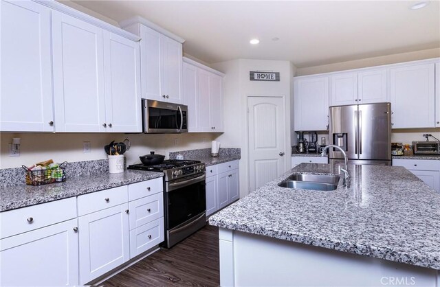 kitchen with stainless steel appliances, white cabinetry, and sink